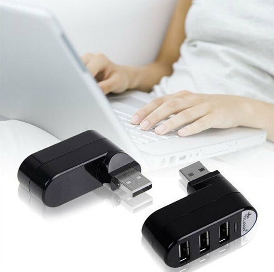 Two USB adapters on a white surface with a person using a laptop in the background.