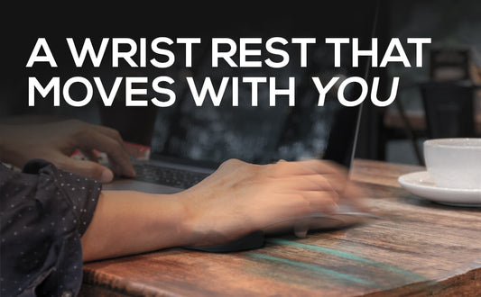 Person using a laptop with a wrist rest on a wooden desk, text overlay 'A Wrist Rest That Moves With You'.