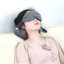 Person wearing a black sleep mask with a blurred background
