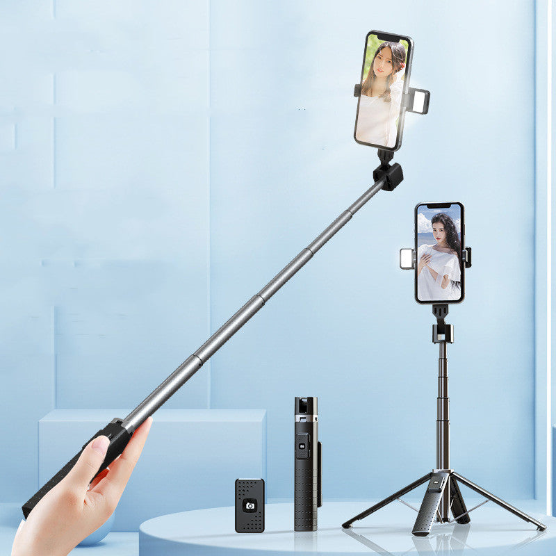 Hand holding a smartphone with a selfie stick against a light blue background