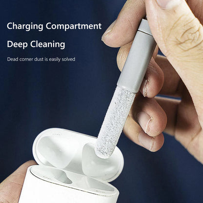 Person cleaning earbuds with a brush over a white case on a dark background