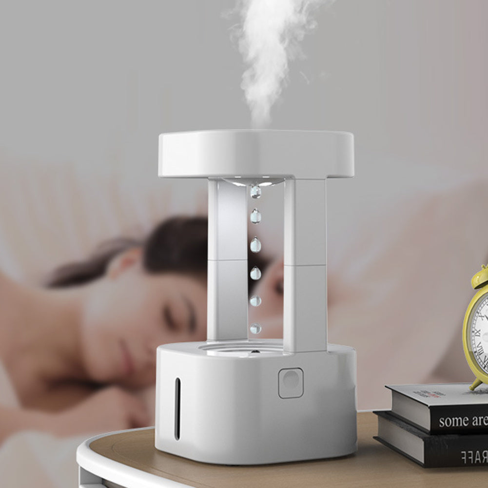 White humidifier emitting mist on a bedside table with a blurred background of a person sleeping.