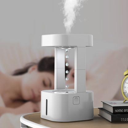 White humidifier emitting mist on a bedside table with a blurred background of a person sleeping.