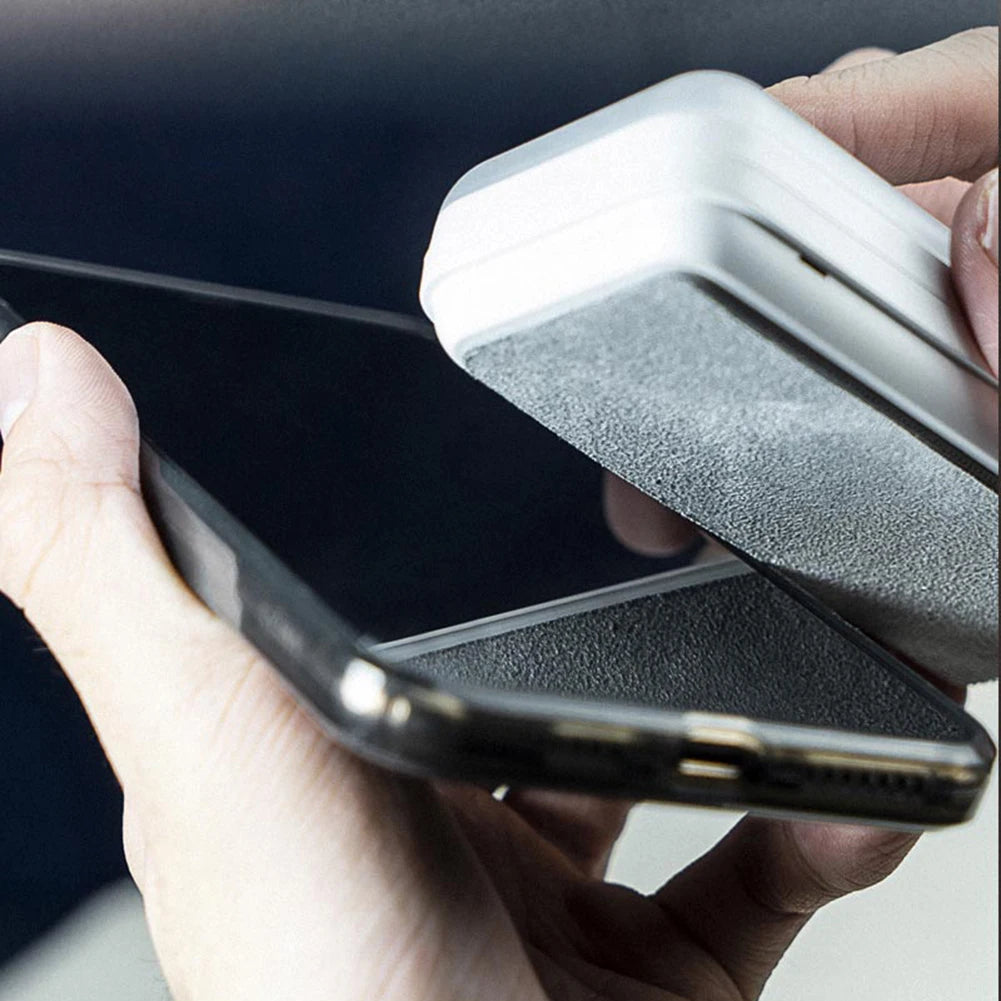 Person cleaning a smartphone screen with a white cleaning tool
