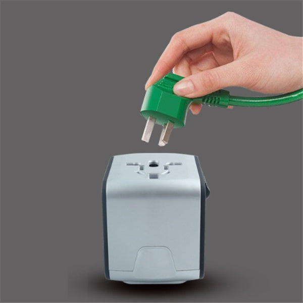 Hand plugging a green plug into a gray power adapter on a dark background