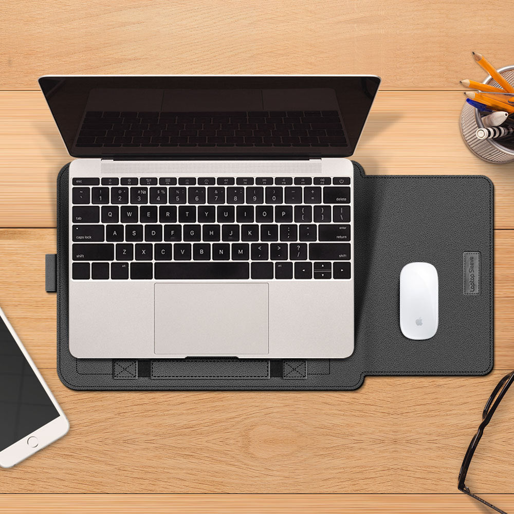 Laptop on a desk with a mouse pad, mouse, smartphone, and stationery items.