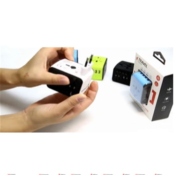Person holding a small electronic device with packaging and additional devices in the background on a white surface.