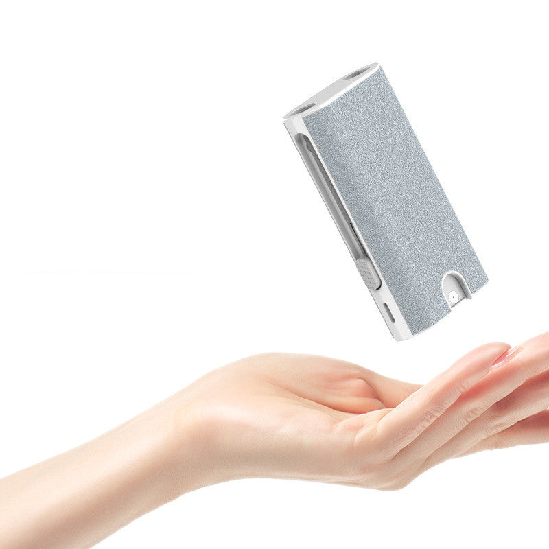 Small rectangular electronic device held in a hand against a white background