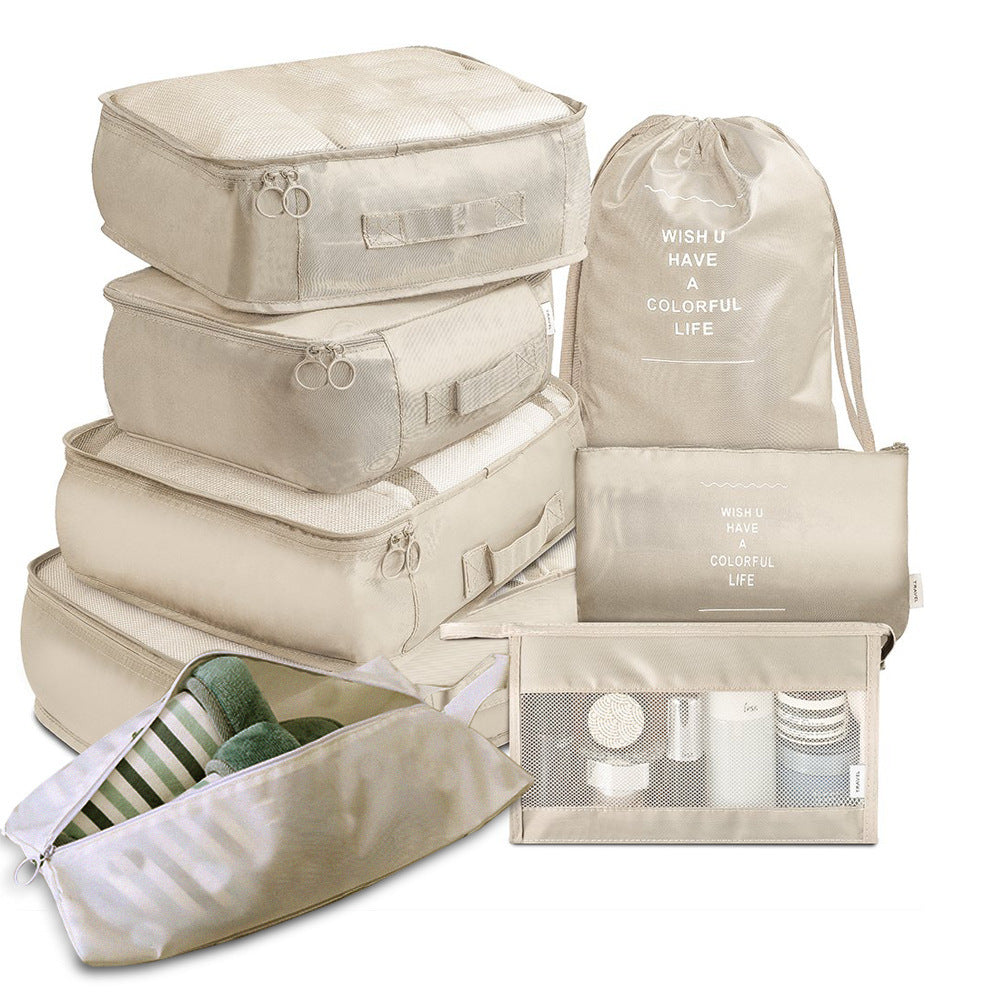 Set of beige travel packing cubes with drawstring bag on a white background