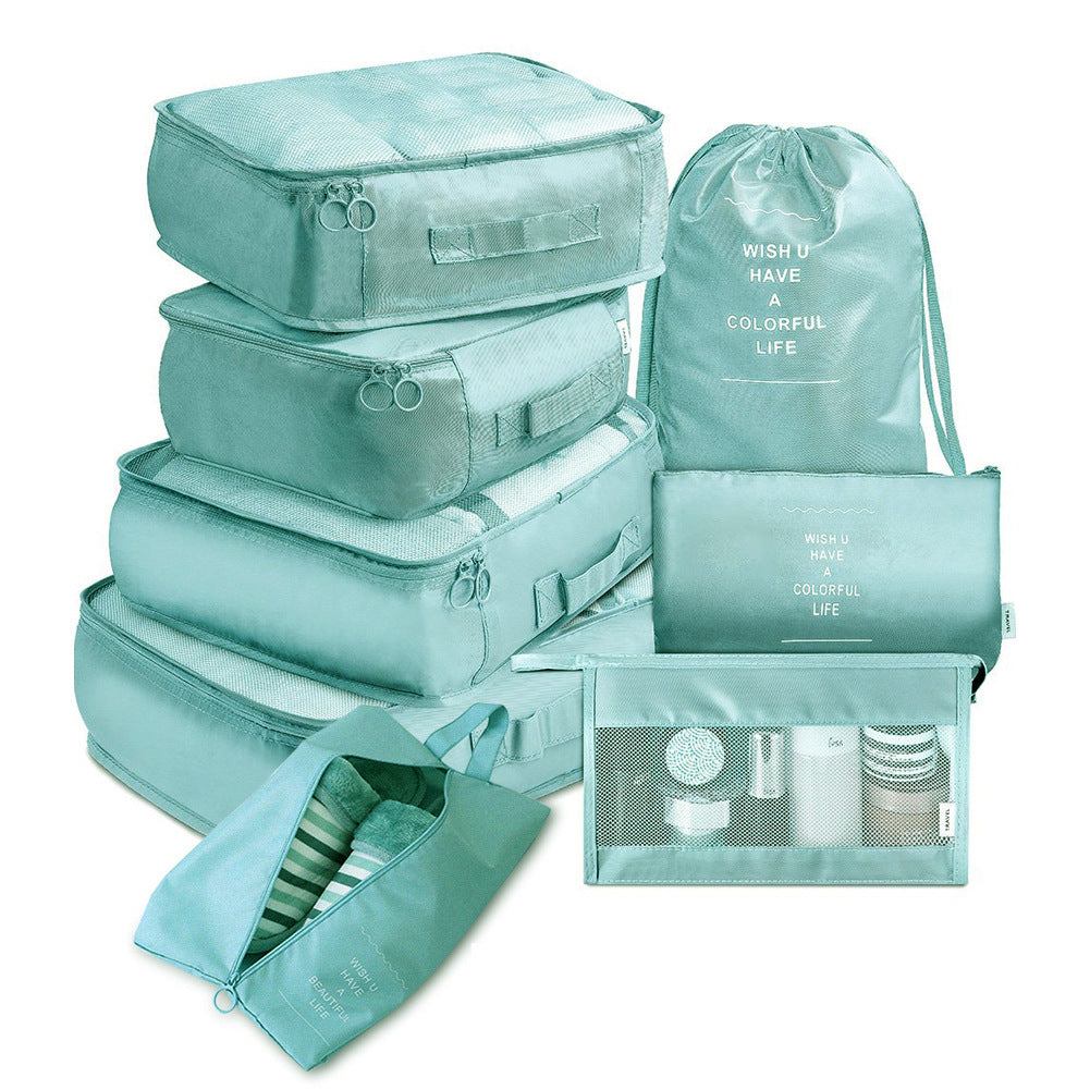 Set of teal packing cubes and bags on a white background