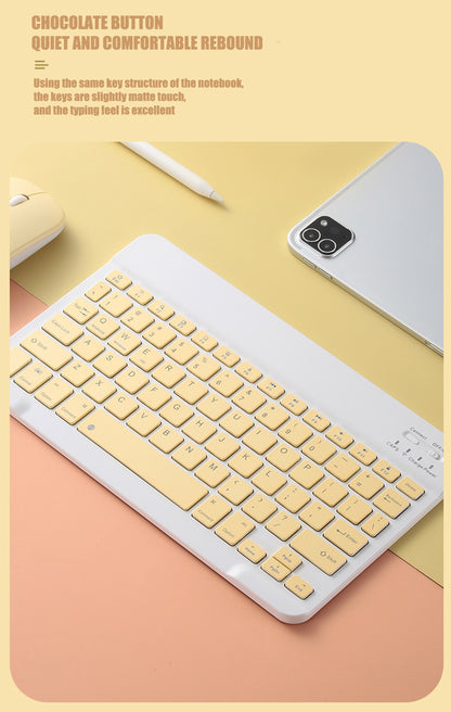 Yellow keyboard on a pink surface with a phone and mouse in the background