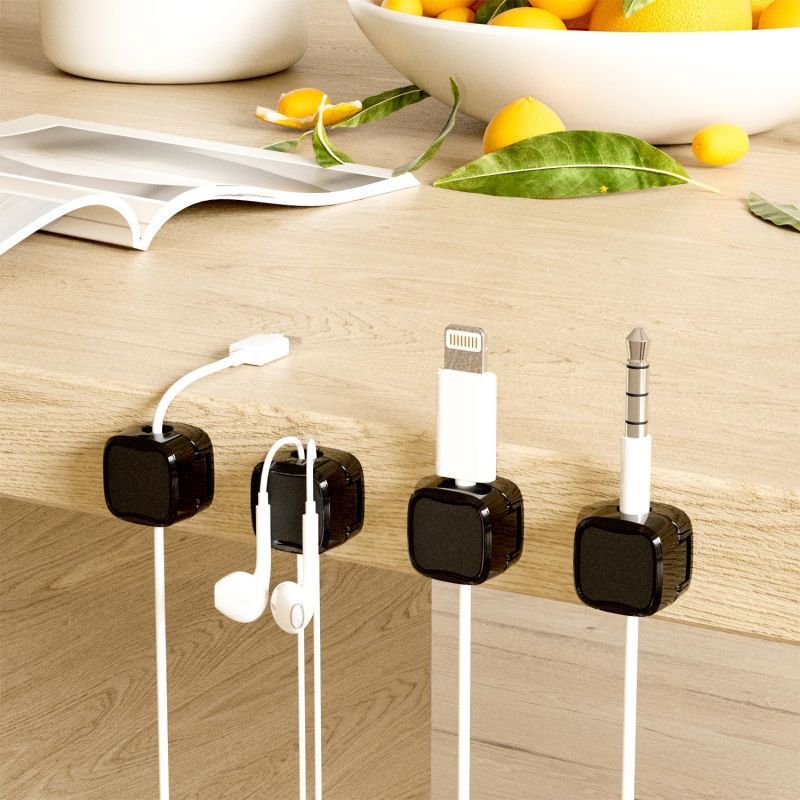 Cable management system with clips holding various electronic cables on a wooden surface.