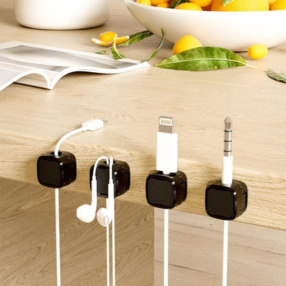 Cable management system with clips holding various electronic cables on a wooden surface.
