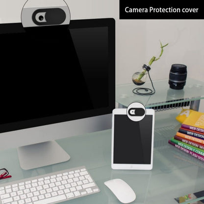 Computer setup with a camera protection cover on a desk