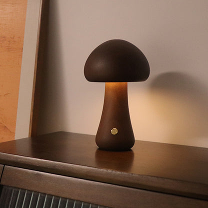 Mushroom-shaped table lamp on a wooden surface with a warm glow.