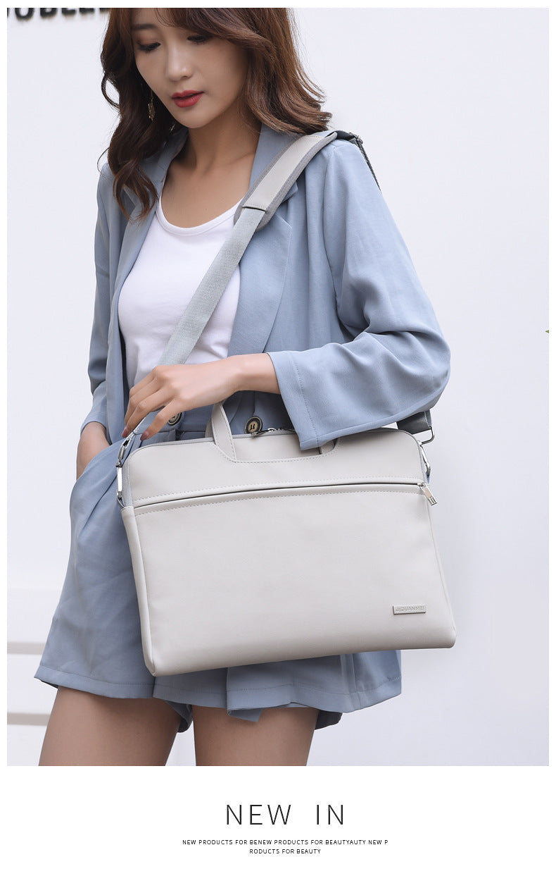 Woman holding a light gray handbag against a white background
