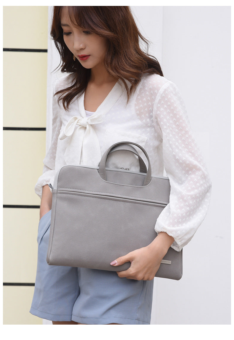 Woman holding a gray handbag against a light background