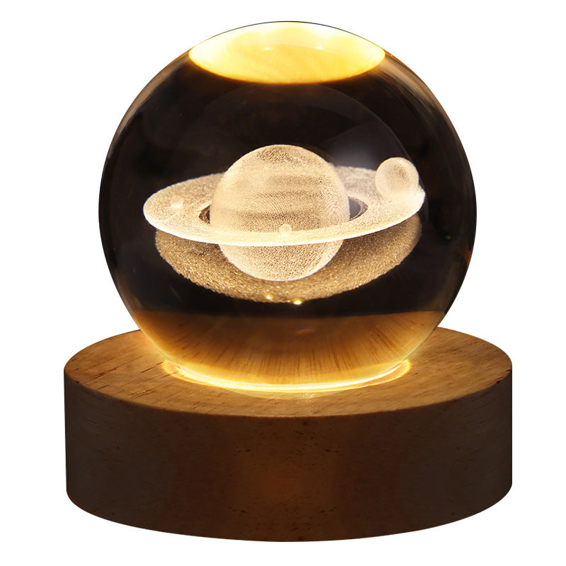 Decorative lamp with Saturn model inside a glass sphere on a wooden base