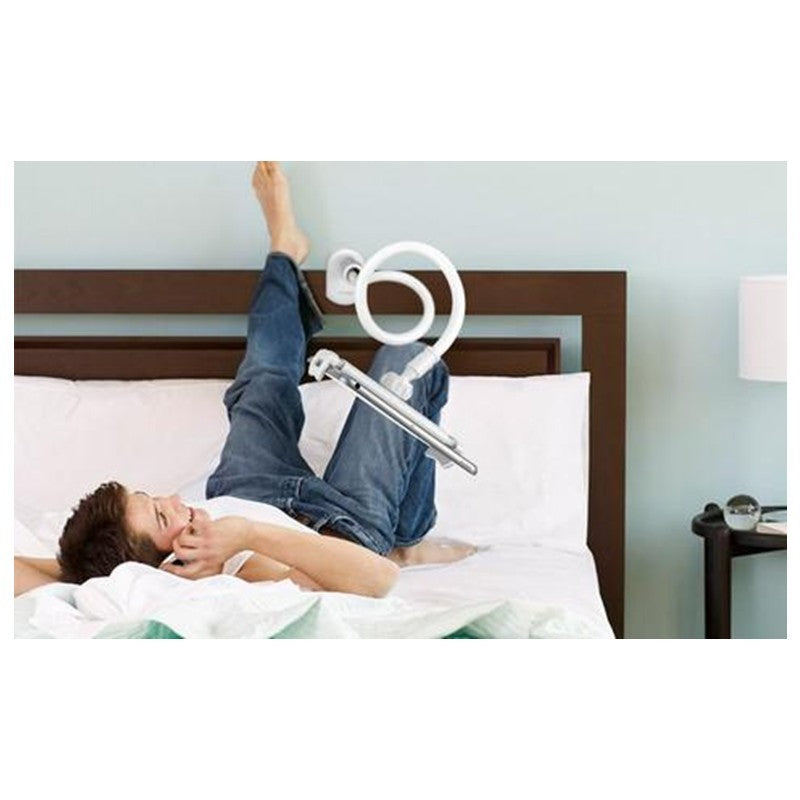 Person lying on a bed with a white circular device attached to their foot.