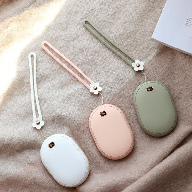 Three small oval-shaped devices with floral straps on a textured surface