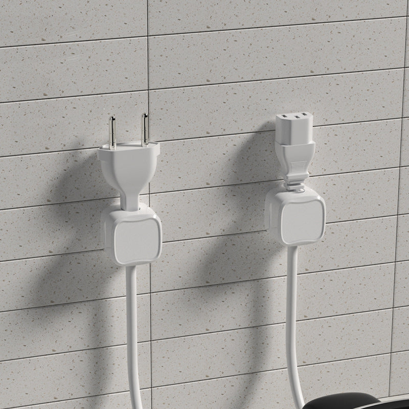 Two white electrical plugs against a gray tiled wall.