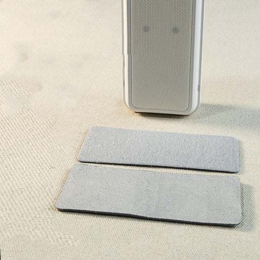 Two gray felt pads on a beige surface with a smartphone above them.