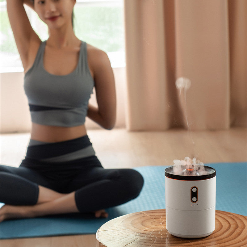 Woman in workout attire sitting on a yoga mat with a white diffuser emitting steam.