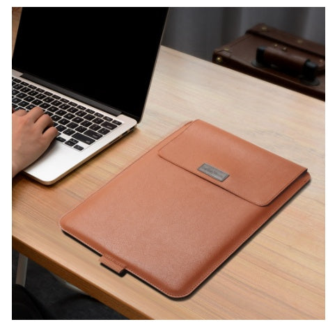 Brown leather laptop sleeve on a desk next to a laptop