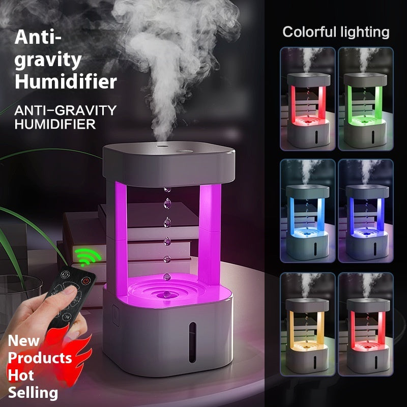 Anti-gravity humidifier with colorful lighting features and a hand holding a remote control.