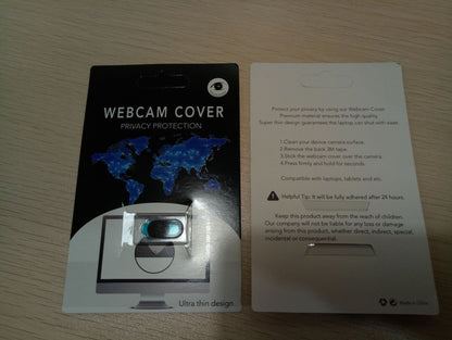 Webcam cover with privacy protection on a card, displayed on a wooden surface.