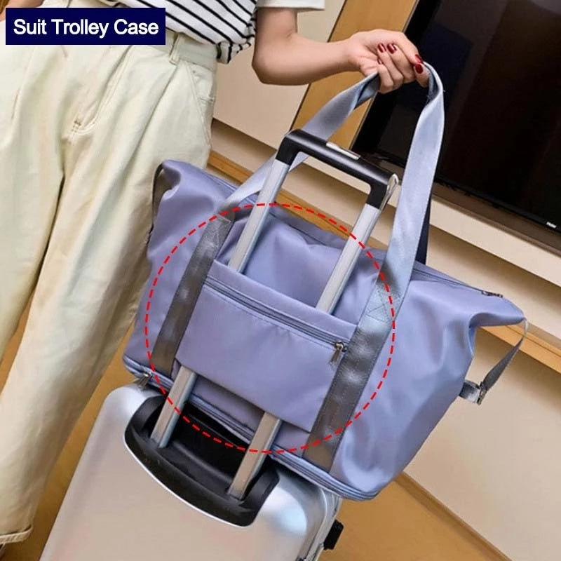 Person holding a blue suit trolley case over a suitcase