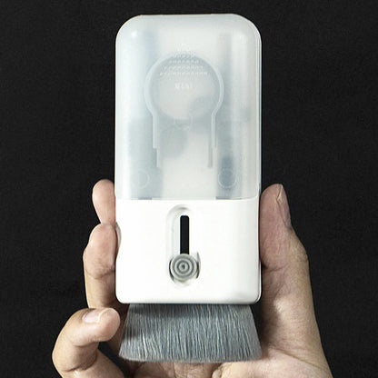 Hand holding a white cleaning brush with a transparent cover against a black background