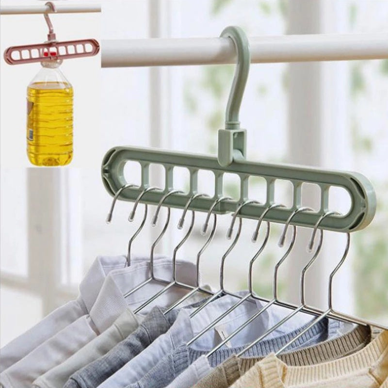 Green multi-hook hanger with clothes on a blurred indoor background