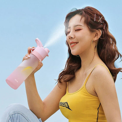 Woman in yellow tank top holding a pink water bottle with mist coming out against a blue sky.