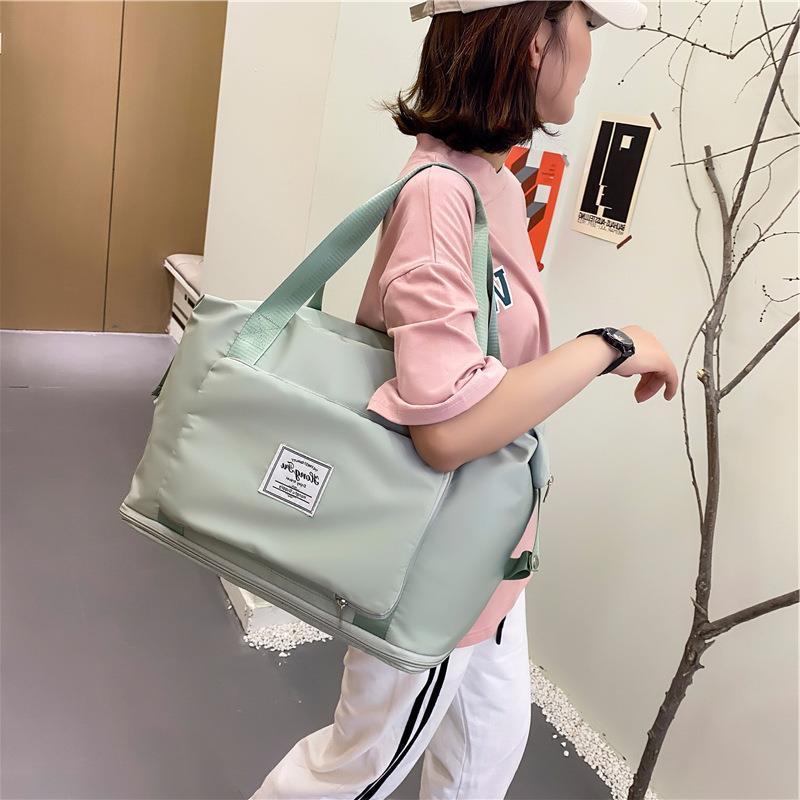 Person holding a light green bag with a visible brand logo in an indoor setting.