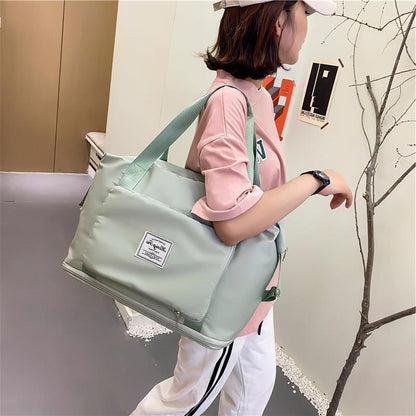 Person holding a light green bag with a visible brand logo in an indoor setting.