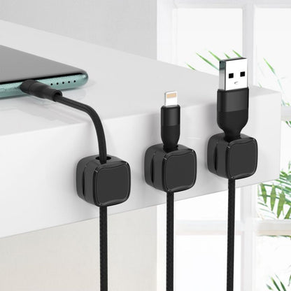 Three black cable organizers with USB connectors on a white surface.