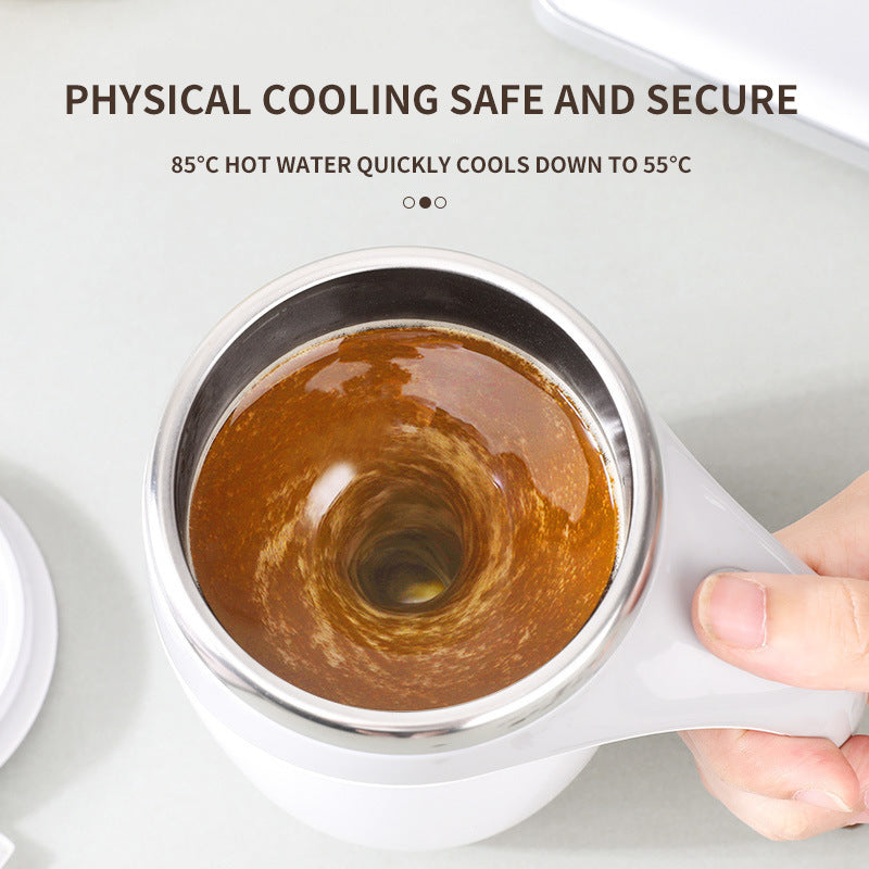 White mug with a metal lid containing hot liquid, held by a hand on a light gray background.