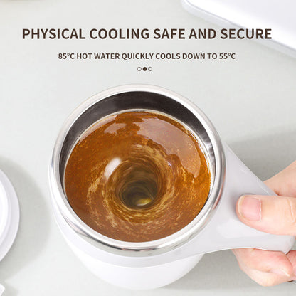 White mug with a metal lid containing hot liquid, held by a hand on a light gray background.