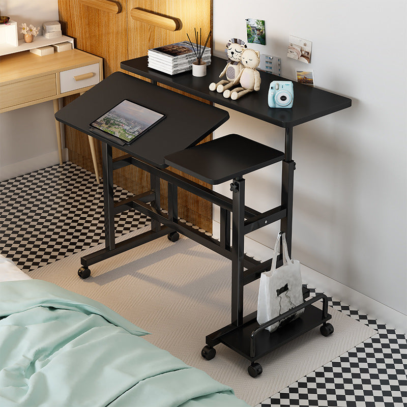 Black adjustable desk in a room with a bed and decor items.