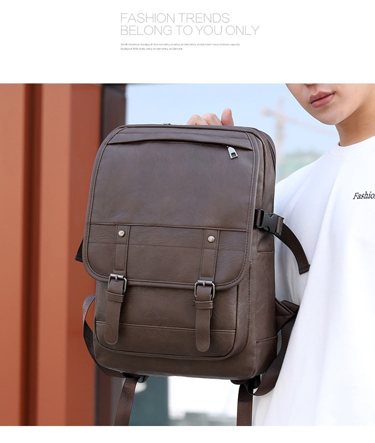 Brown backpack held by a person with a blurred background