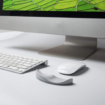 Computer monitor with keyboard, mouse, and wrist rest on a desk