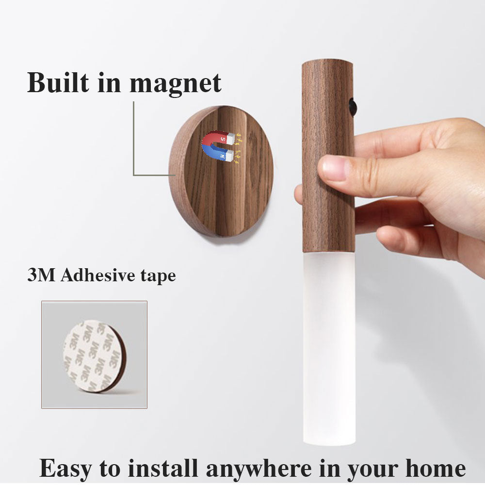 Wooden wall hook with magnetic feature and adhesive tape, held by a hand on a white background.