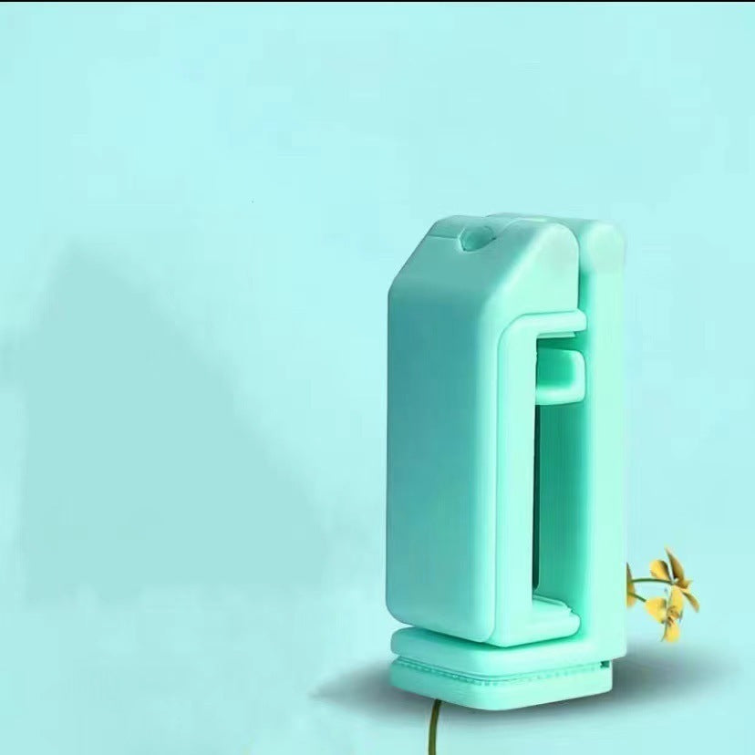 Turquoise-colored device with a handle on a light blue background