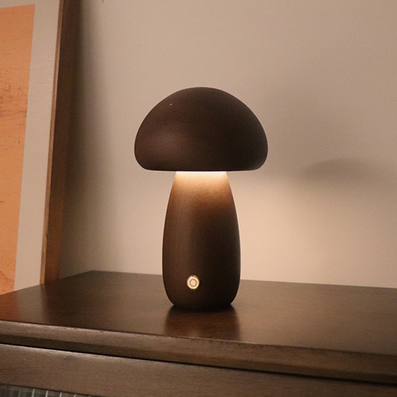 Mushroom-shaped lamp on a wooden surface with a warm glow