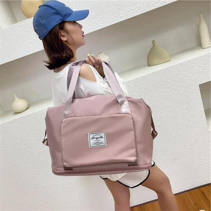 Woman holding a pink duffel bag with a white label indoors.