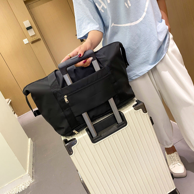 Person holding a black suitcase on a ramp indoors