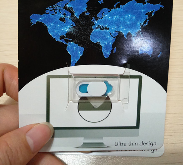 Hand holding a small electronic device with a world map in the background