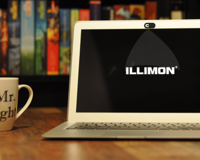 Laptop displaying the 'ILLIMON' logo on a wooden desk with books in the background