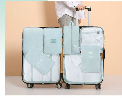 Set of light blue travel packing cubes with a suitcase on a beige background
